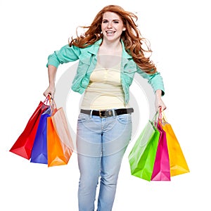 Smiling young redhead girl with colorful shoppingbags photo