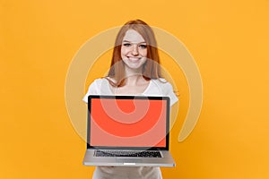 Smiling young redhead woman girl in white t-shirt posing isolated on yellow background studio portrait. People lifestyle