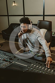 smiling young sound producer sitting