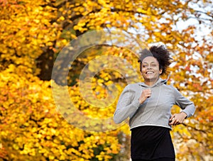 Smiling young sports woman running outdoors