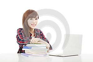 Smiling young student girl with book and laptop isolated on whit