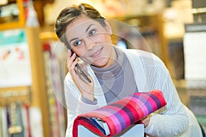 smiling young tailor using smart phone