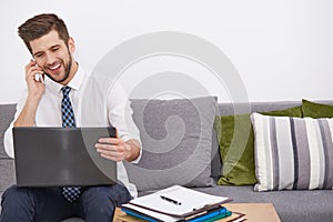 Smiling young telecommuter with laptop photo