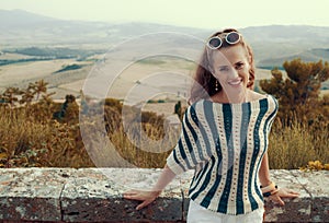 Smiling young tourist woman in front of scenery of Tuscany