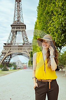 Smiling young traveller woman speaking on cell phone