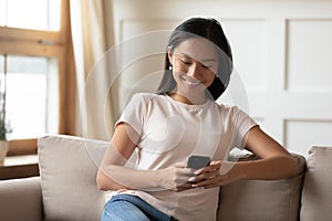 Smiling young vietnamese woman using mobile applications.