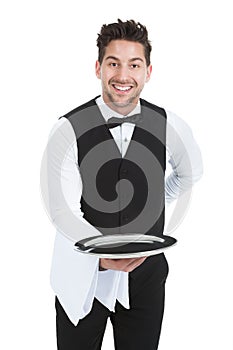 Smiling Young Waiter Holding Empty Serving Tray