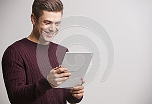 Smiling young white man holding a tablet computer