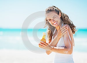 Giovane donna l'uso il sole bloccare sul Spiaggia 
