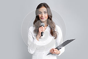 Smiling young woman as reporter with microphone and clipboard. Female journalist with microphone and clipboard.