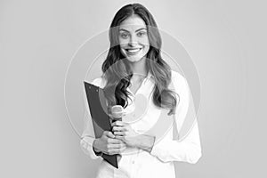 Smiling young woman as reporter with microphone and clipboard. Female journalist with microphone and clipboard.