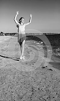 Smiling young woman on beach in evening having fun time