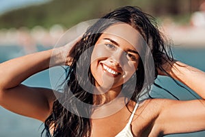 smiling young woman in bikini swimsuit on beach