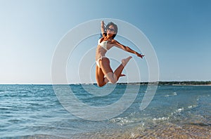 smiling young woman in bikini swimsuit on beach