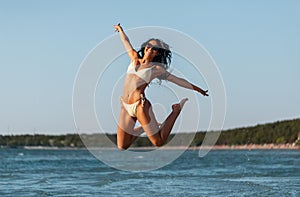 smiling young woman in bikini swimsuit on beach