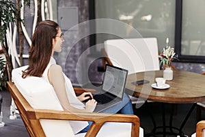 smiling young woman browsing through email on her laptop.