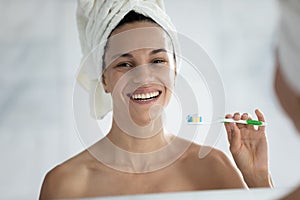 Smiling young woman brush teeth in home bathroom