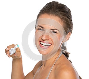 Smiling young woman brushing teeth