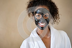 Smiling woman with charcoal face mud photo