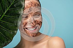 Smiling young woman with coffee scrub