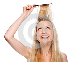Smiling young woman combing hair