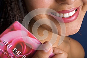 Smiling young woman with a credit card