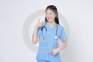 Smiling young woman doctor with stethoscope showing thumbs up isolate on white background
