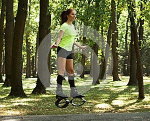 Smiling young woman doing exercises in kangoo jumps shoes
