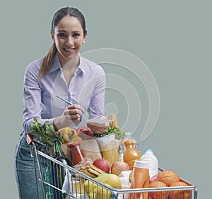 Smiling young woman doing grocery shopping