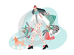 Smiling young woman dressed in trendy outerwear walking her poodle dog on leash and carrying bags with purchased