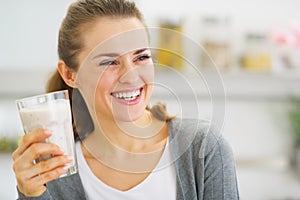 Smiling young woman drinking fresh cocktail