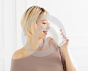 Smiling young woman drinking milk