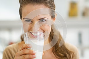 Smiling young woman drinking milk