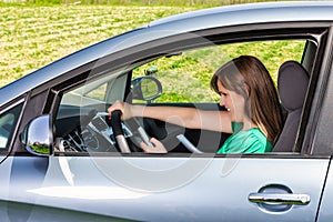 Smiling young woman driver reading/typing a text message