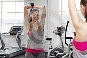 Smiling young woman with dumbbells in the gym. Active lifestyle and health