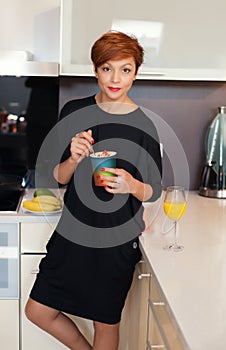 Smiling young woman eating fresh fruits