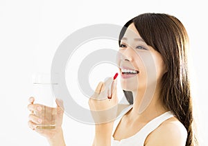 Smiling young woman eating the pill