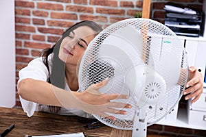 Woman Enjoying Breeze With Electric Fan photo