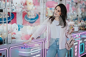 Smiling young woman enjoying a game at an arcade with neon lights