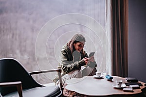 Smiling young woman enjoying time on a cozy day indoors with friends