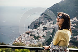 Smiling young woman enoying seaview in Positano,Italy. Vacation on Amalfi coast.Happy tourist in Europe.Italian coast beauty,