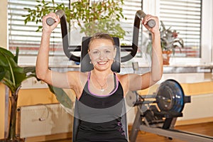 Smiling young woman exercising in gym