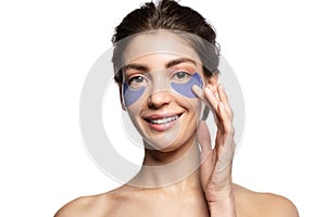 Smiling young woman face with eye patches studio portrait.