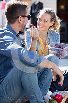 smiling young woman feeding loving man