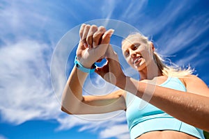 smiling young woman with fitness tracker outdoors