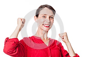 Smiling young woman gesturing and expressing fun victory
