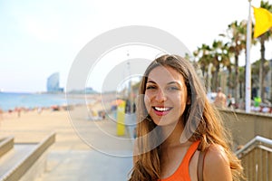 Smiling young woman going to Barceloneta, famous Barcelona beach, Catalonia, Spain.