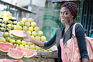 Smiling young woman grabs a slice of ripe fruit.