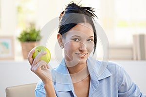 Smiling young woman with green apple