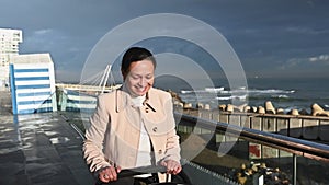 Smiling young woman, a happy mother walking with her baby sleeping in baby buggy